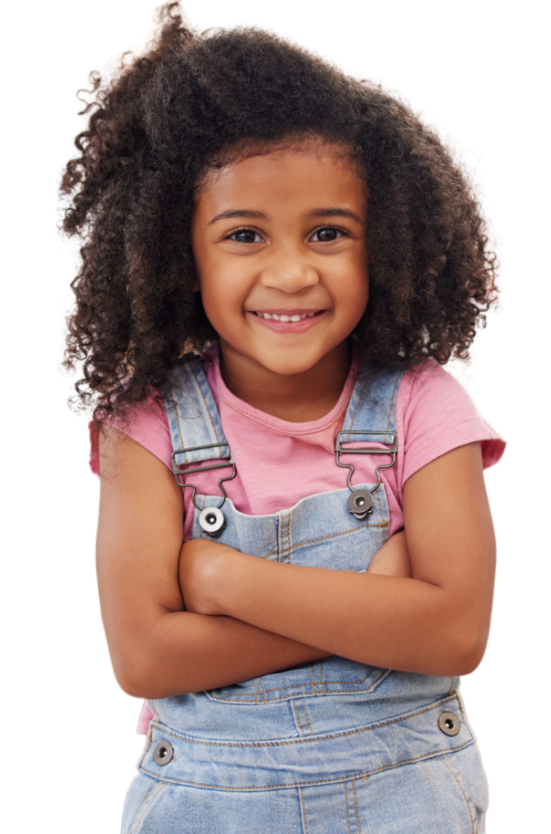 Young black girl wearing overalls smiles at the camera with her arms crossed