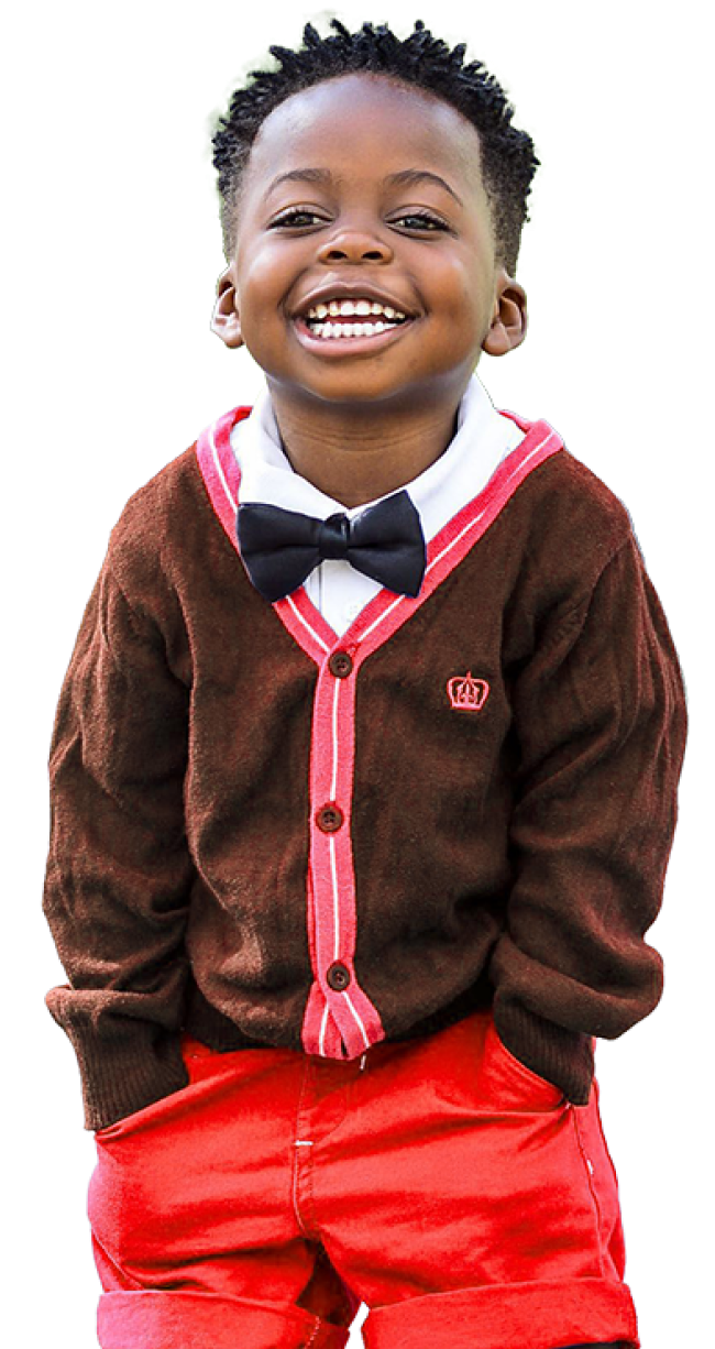 Young Black boy wearing a bow tie and cardigan smiles at the camera